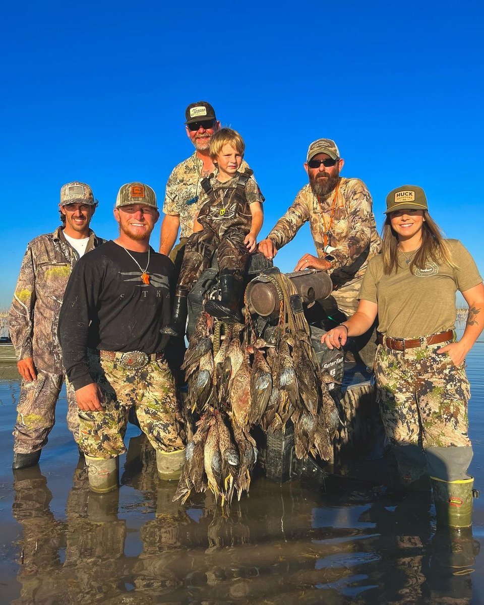 Group of hunters with ducks in the water