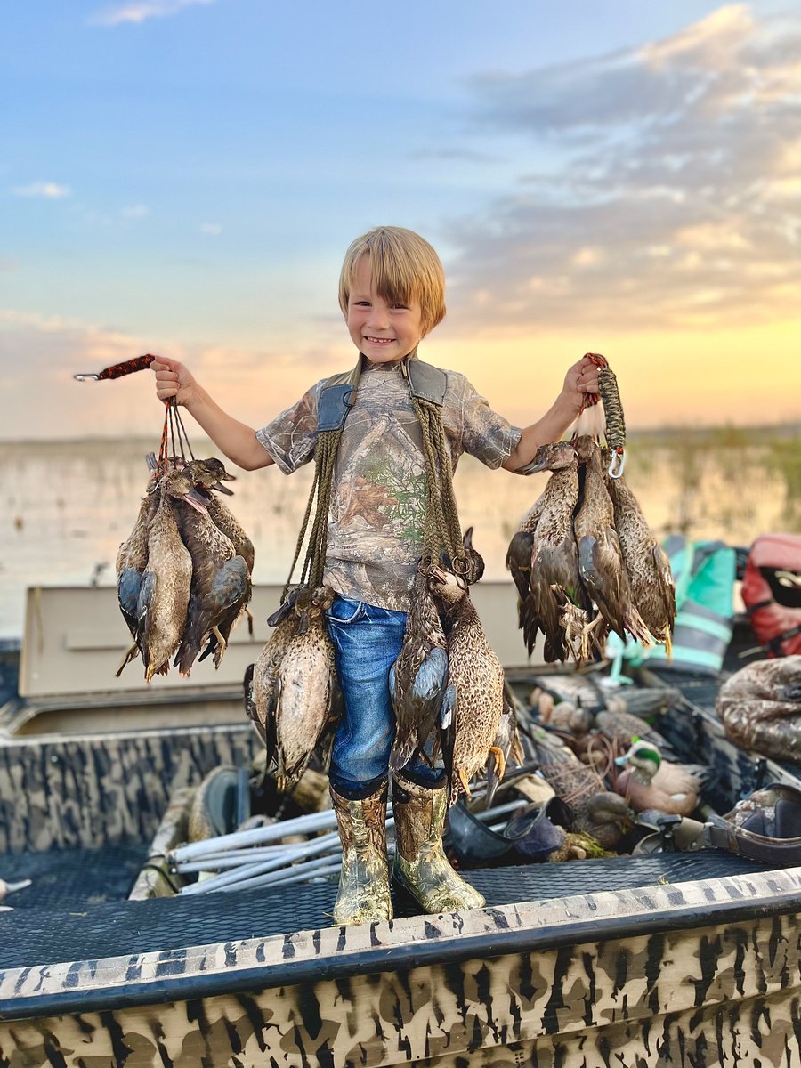 Kid hunter holding deceased ducks