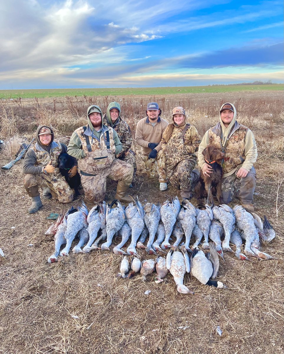 Group of hunters with deceased sandhill cranes, geese, and ducks