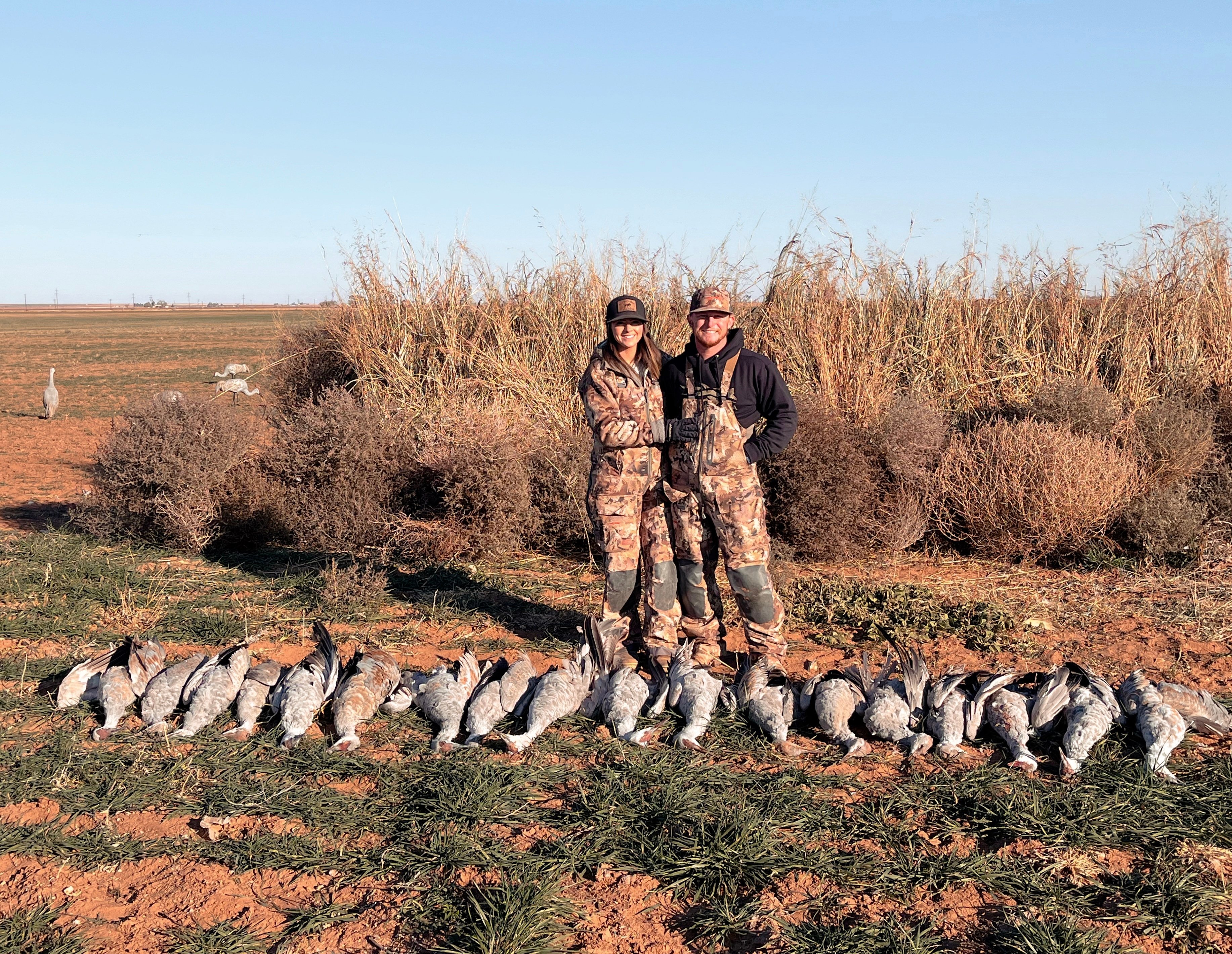 Male and female hunter with deceased sandhill cranes