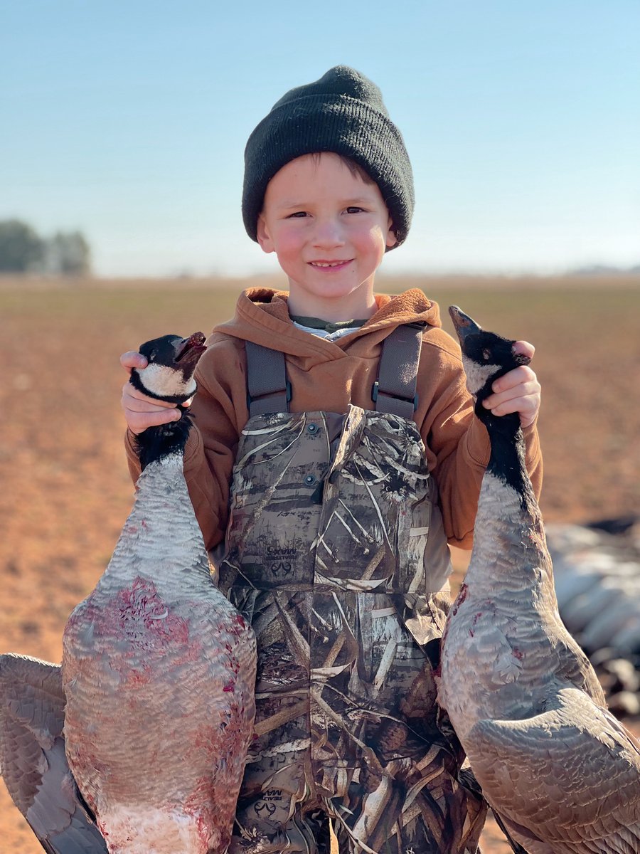 Kid hunter holding two deceased geese