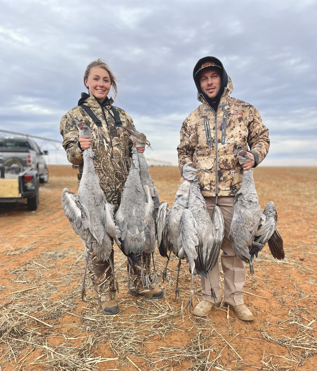 Male and female hunter holding deceased sandhill cranes